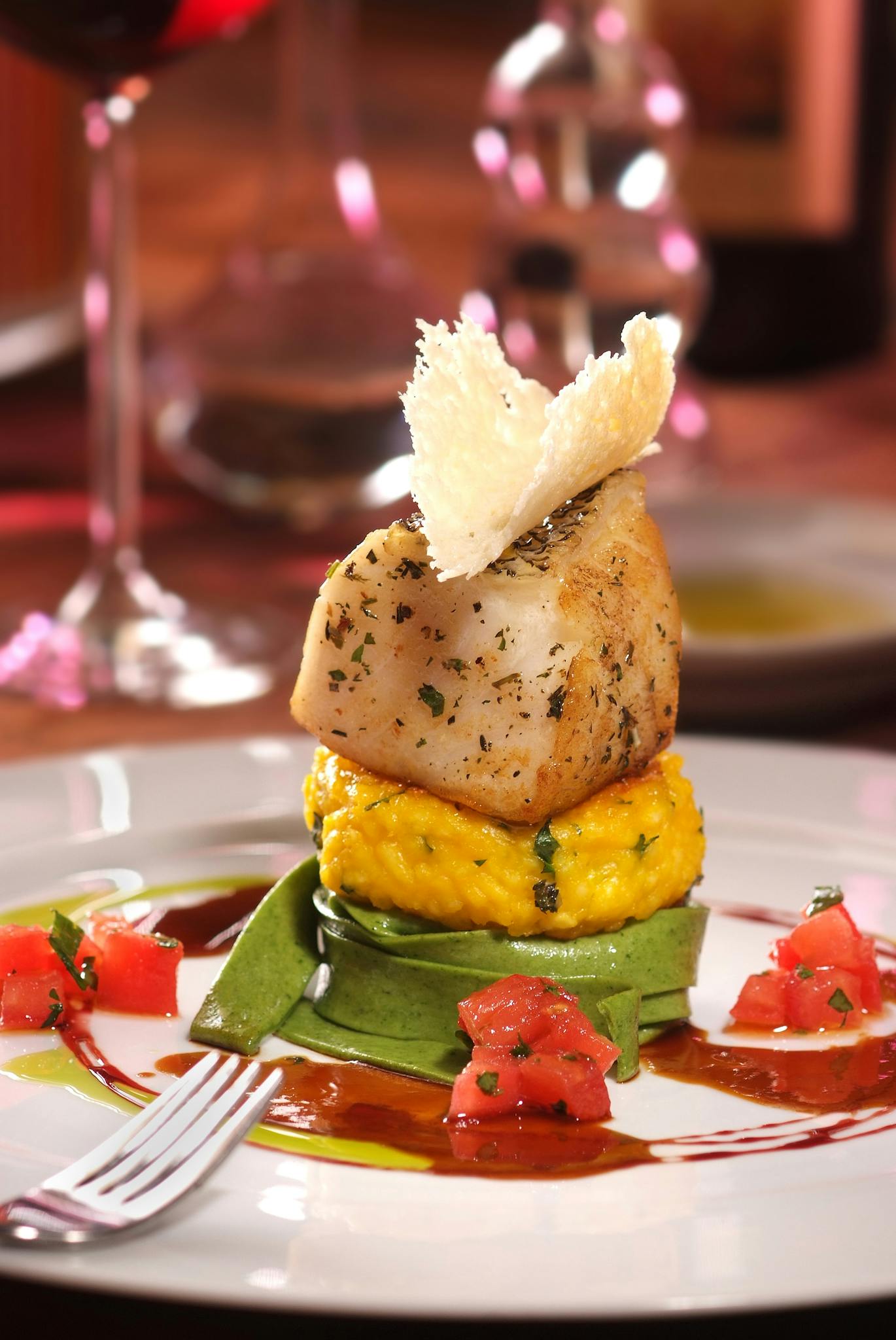 Elegant gourmet dish featuring seafood over vegetable puree with artistic presentation.
