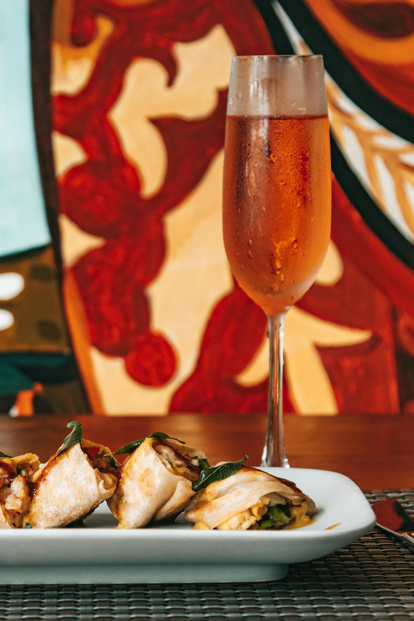 Savory appetizers paired with a sparkling beverage against a colorful backdrop.